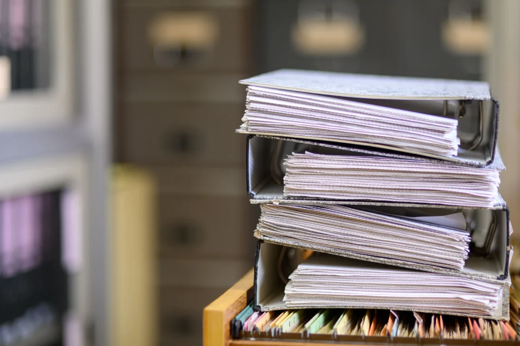 Documentos de empresa apilados para organizar en archivo físico